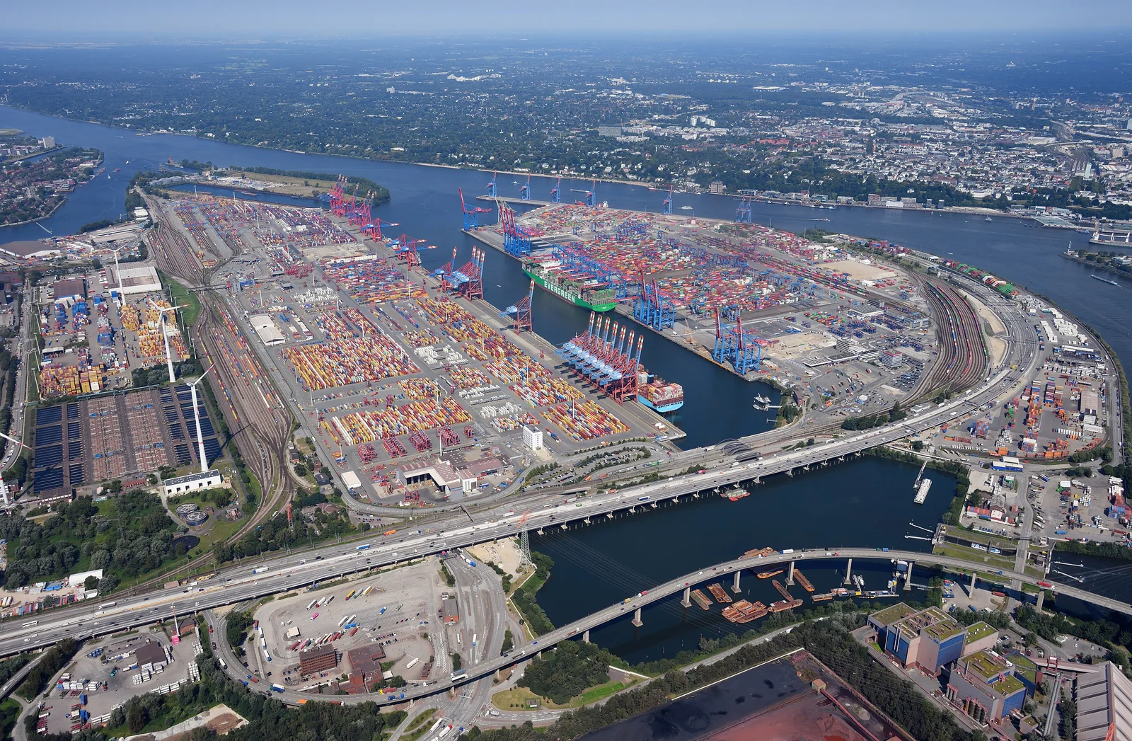 An aerial view of shipping containers and gantry cranes at a cargo terminal